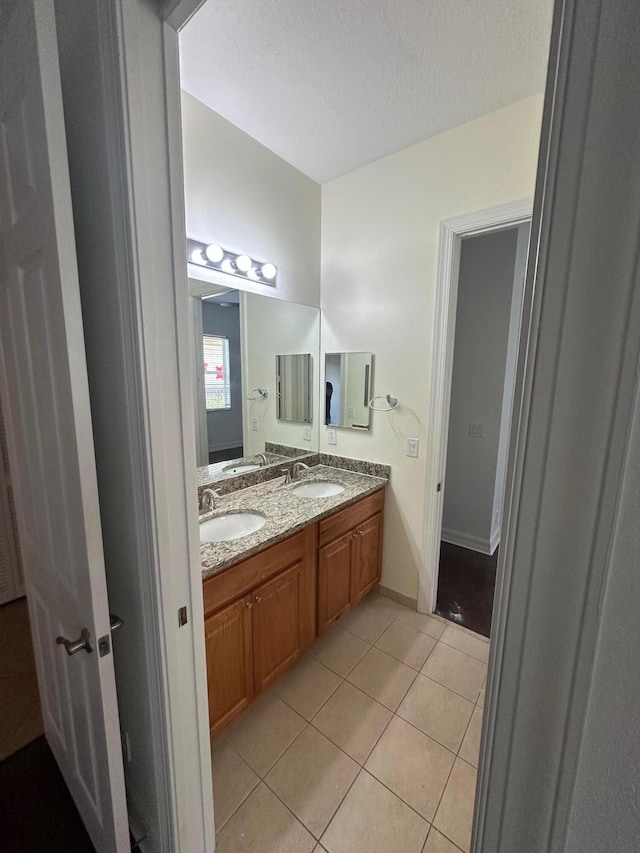 bathroom with tile patterned floors, vanity, and a textured ceiling