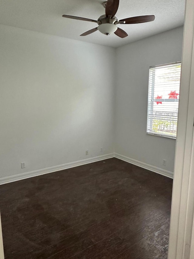 unfurnished room featuring ceiling fan, dark wood-type flooring, and a textured ceiling