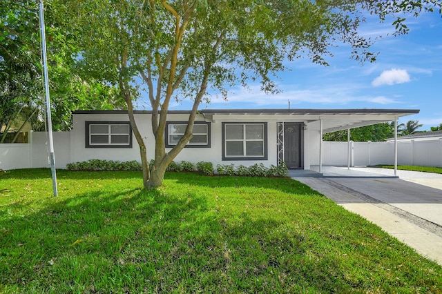 ranch-style house featuring a front yard and a carport