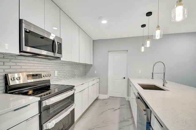 kitchen with sink, appliances with stainless steel finishes, light stone counters, and white cabinetry