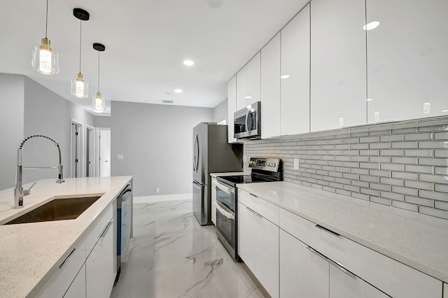 kitchen with white cabinets, backsplash, sink, pendant lighting, and stainless steel appliances