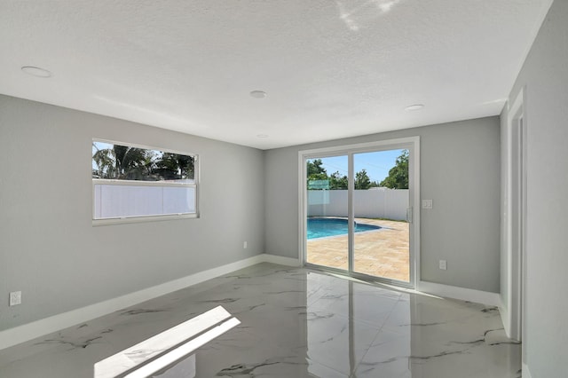 unfurnished room with a textured ceiling