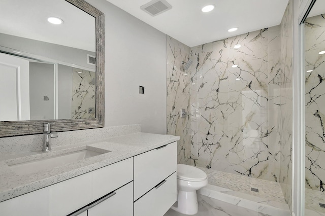 bathroom featuring vanity, toilet, and a tile shower