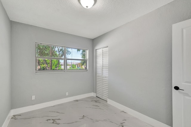 spare room with a textured ceiling