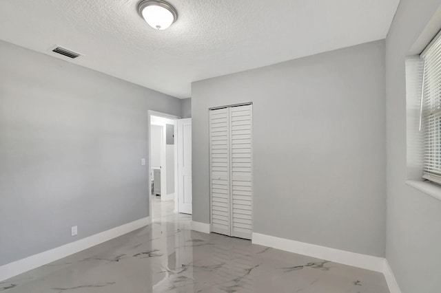 unfurnished bedroom featuring a closet and a textured ceiling