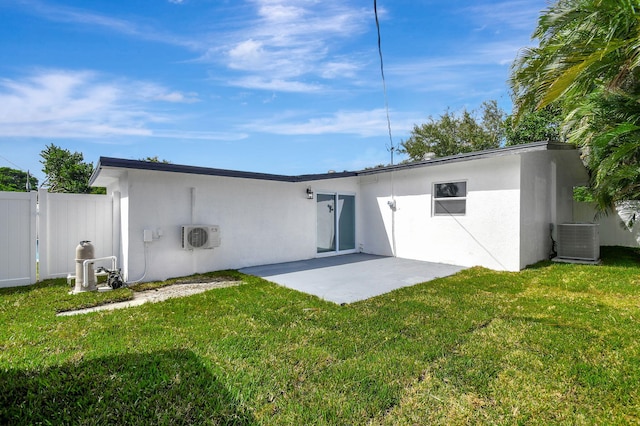 back of property with a patio, central AC, and a lawn