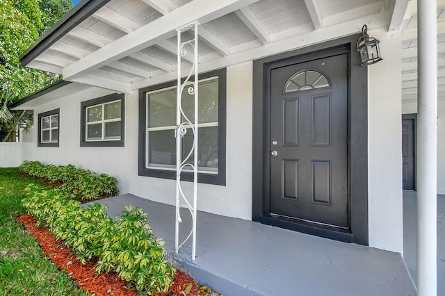 view of exterior entry featuring covered porch