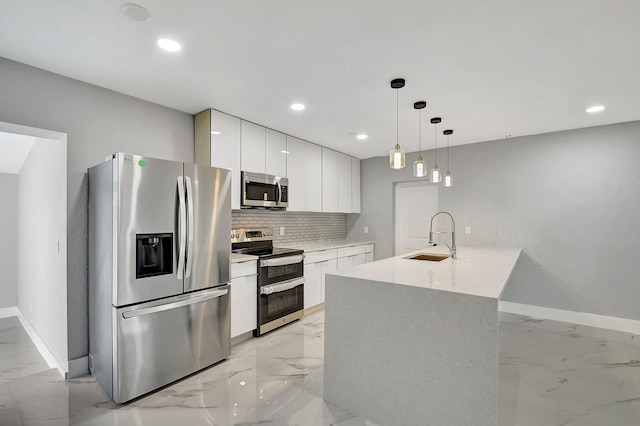 kitchen featuring sink, white cabinetry, stainless steel appliances, pendant lighting, and decorative backsplash