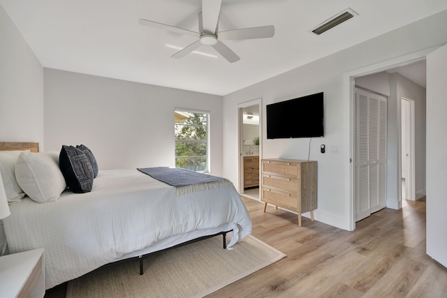 bedroom featuring ceiling fan, light hardwood / wood-style floors, connected bathroom, and a closet