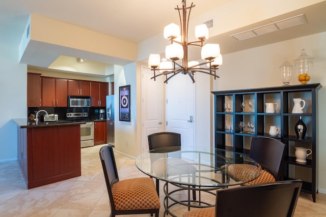 tiled dining area featuring sink and a notable chandelier