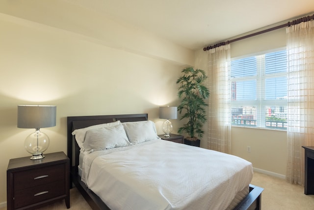 bedroom with light carpet and multiple windows