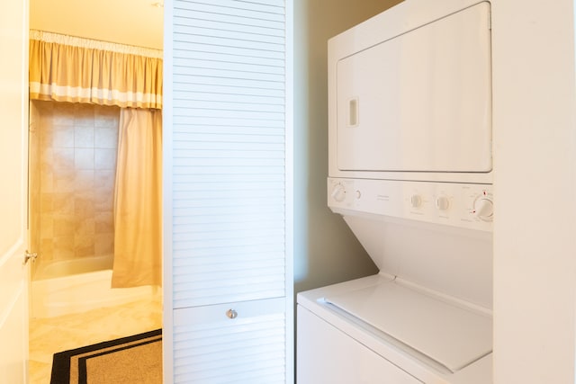 laundry room featuring stacked washer and dryer and tile patterned flooring