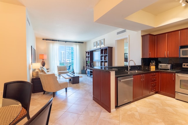 kitchen featuring stainless steel appliances, kitchen peninsula, sink, tasteful backsplash, and light tile patterned floors