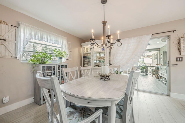 dining space with light wood-type flooring and a chandelier