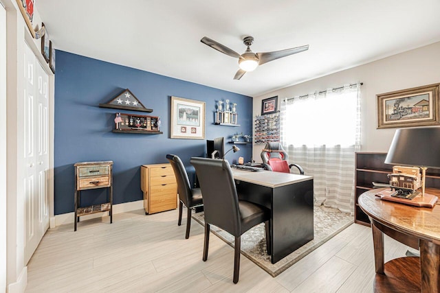 home office with light hardwood / wood-style floors and ceiling fan