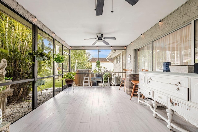 sunroom / solarium featuring ceiling fan