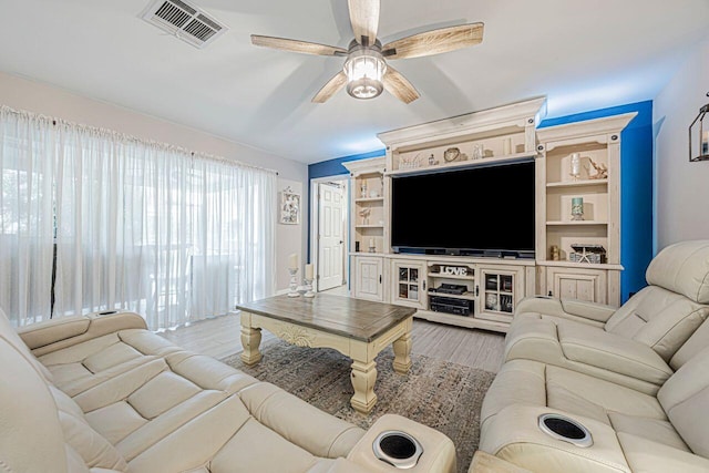 living room featuring light hardwood / wood-style flooring and ceiling fan