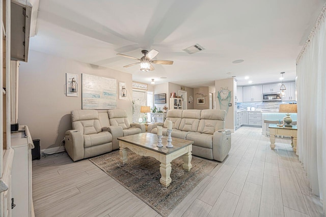 living room with light hardwood / wood-style floors and ceiling fan