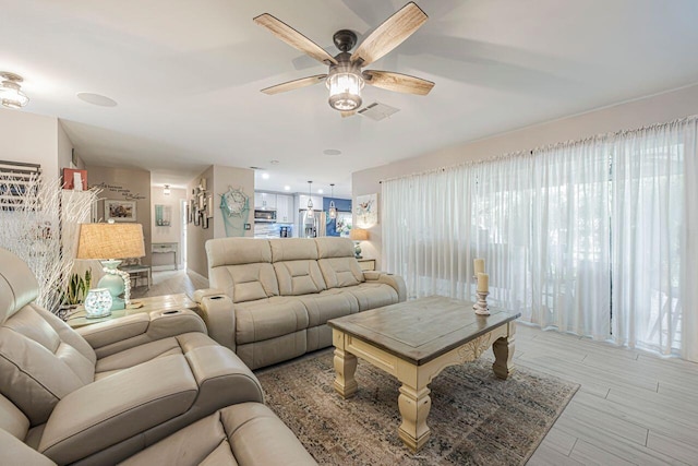 living room featuring ceiling fan and light hardwood / wood-style flooring