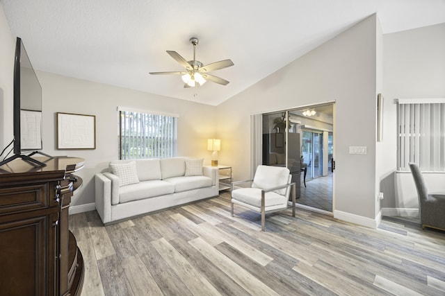 living room with light wood-type flooring, ceiling fan, and vaulted ceiling