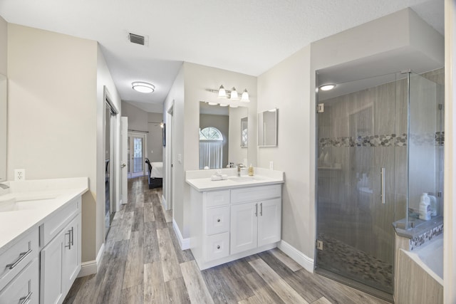 bathroom featuring vanity, an enclosed shower, hardwood / wood-style floors, and a textured ceiling