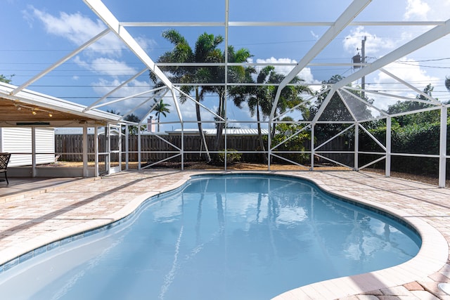 view of swimming pool featuring a patio and a lanai