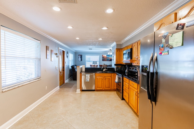 kitchen featuring appliances with stainless steel finishes, kitchen peninsula, ornamental molding, and plenty of natural light