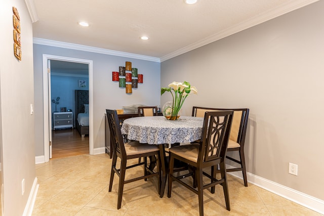 tiled dining space featuring ornamental molding