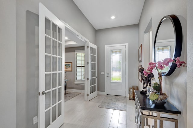 entryway featuring french doors, light wood-type flooring, and a wealth of natural light