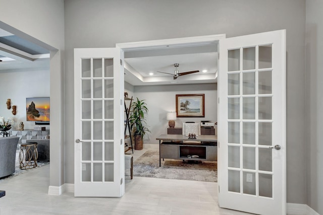 entryway with french doors, a raised ceiling, and ceiling fan