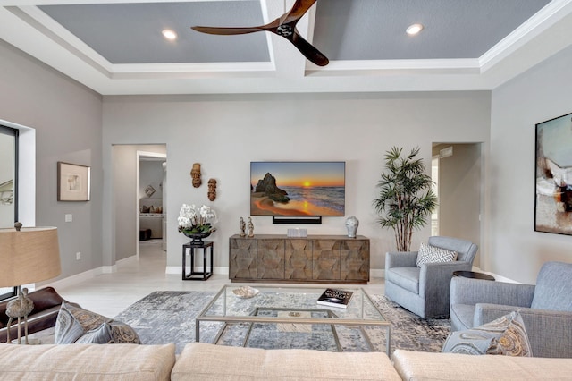 living room featuring ceiling fan, crown molding, and a tray ceiling