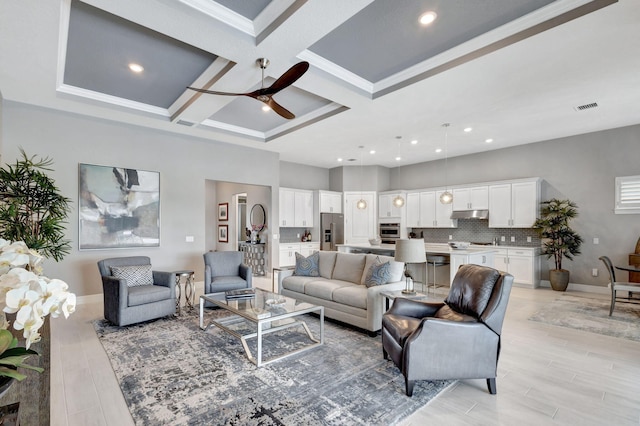 living room featuring light hardwood / wood-style flooring, beamed ceiling, coffered ceiling, and ceiling fan