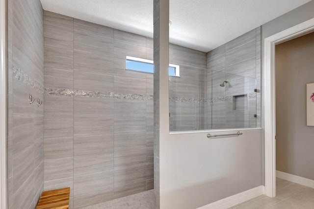 bathroom featuring a textured ceiling and tiled shower