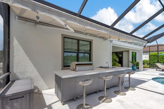 view of patio featuring grilling area, an outdoor bar, and a lanai