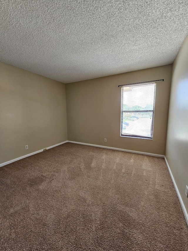 carpeted spare room with a textured ceiling