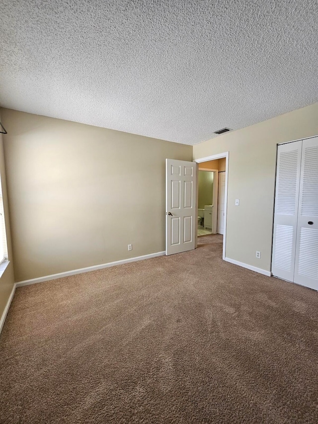 unfurnished bedroom with a closet, carpet flooring, and a textured ceiling