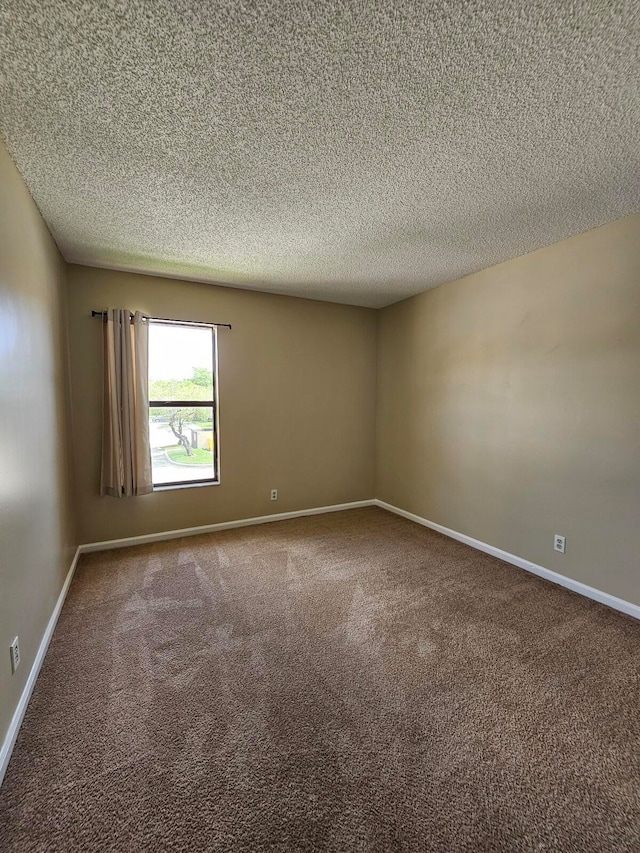 carpeted spare room with a textured ceiling