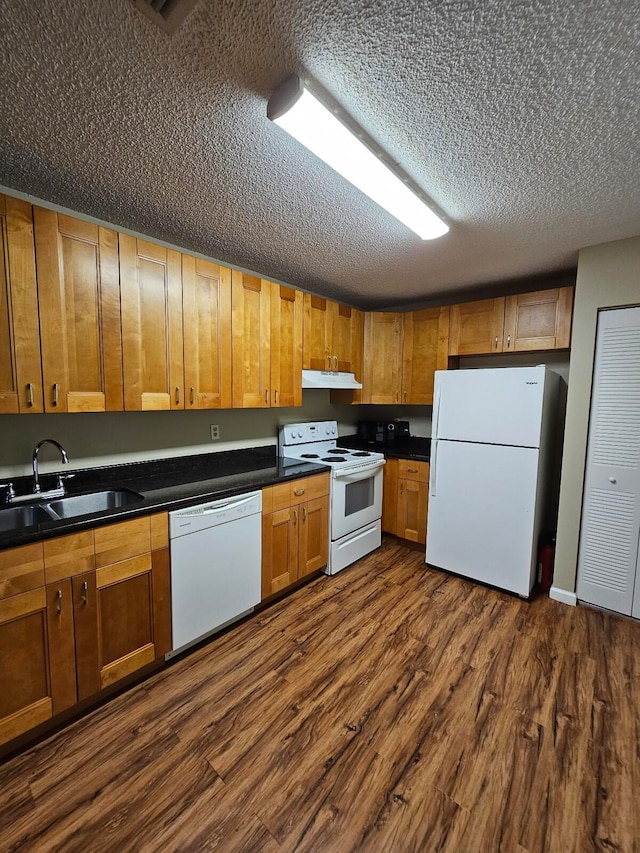 kitchen with sink, a textured ceiling, white appliances, and dark hardwood / wood-style flooring