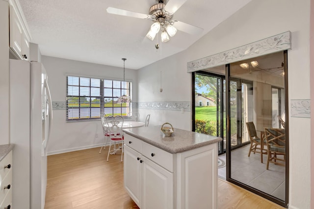 8282 Mooring Cir, Boynton Beach, FL 33472 - kitchen featuring freestanding refrigerator, ceiling fan, light wood-style floors, and white cabinetry