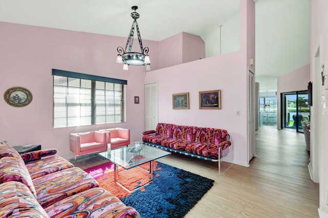 living room featuring light hardwood / wood-style floors, a chandelier, and high vaulted ceiling