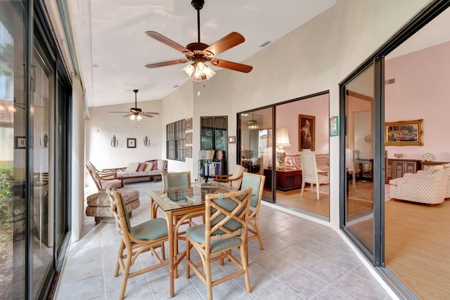 dining space featuring light hardwood / wood-style floors, high vaulted ceiling, and ceiling fan