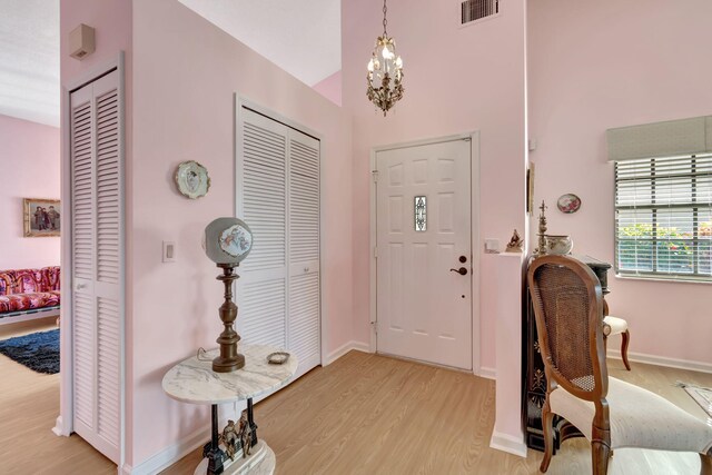 entrance foyer with light hardwood / wood-style floors and a chandelier