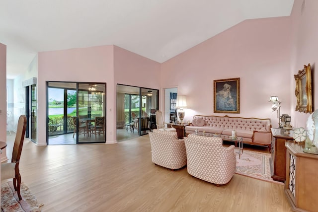 living room with high vaulted ceiling and light hardwood / wood-style flooring