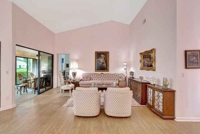 living room featuring high vaulted ceiling, light wood-type flooring, and ceiling fan