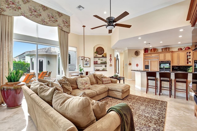 living room featuring a towering ceiling, ornamental molding, and ceiling fan