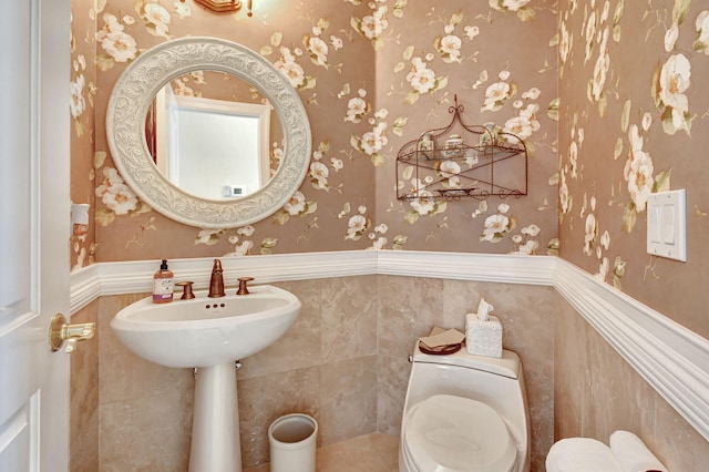 bathroom featuring toilet and tile walls