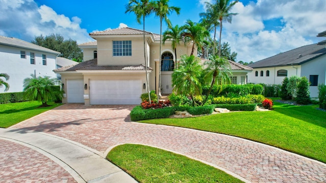 mediterranean / spanish house featuring a front lawn and a garage