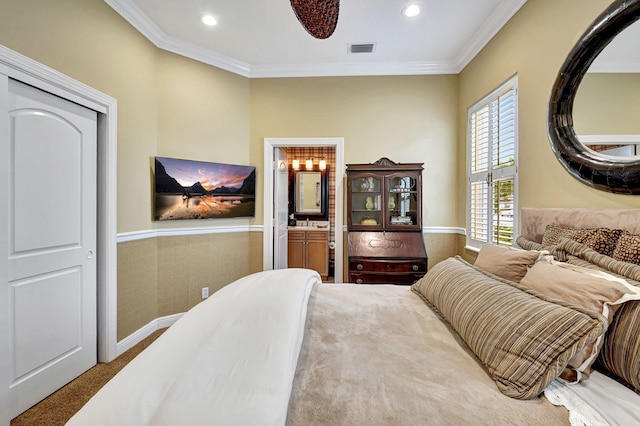 carpeted bedroom featuring connected bathroom and ornamental molding