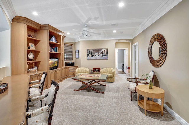 carpeted living room with crown molding and ceiling fan