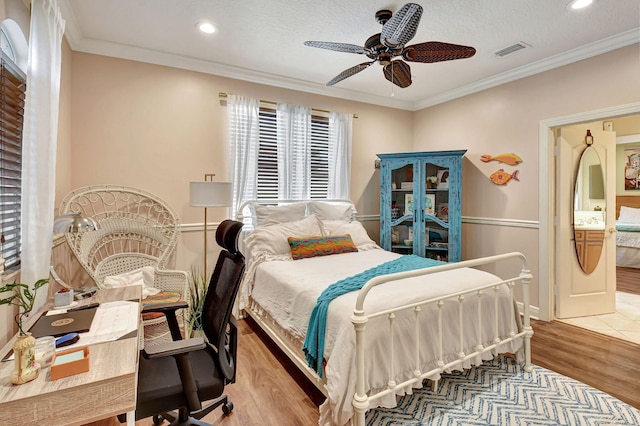 bedroom with ornamental molding, a textured ceiling, light wood-type flooring, and ceiling fan